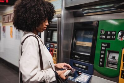 Voyageuse utilisant un distributeur automatique de titres de transport dans une station